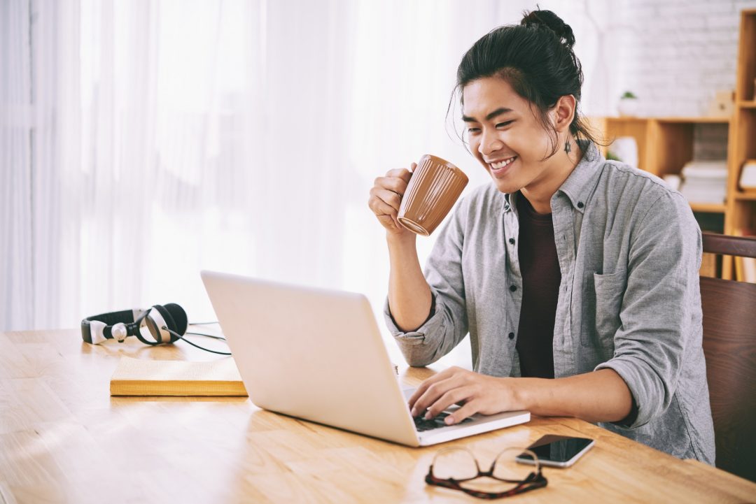 MAN BROWSING INTERNET WIHT COFEE